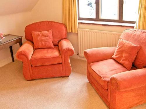 a living room with a chair and a couch at Brock Cottage in Beaulieu