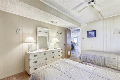 a bedroom with two beds and a dresser with a mirror at Sea Terrace Serenity in Ocean City