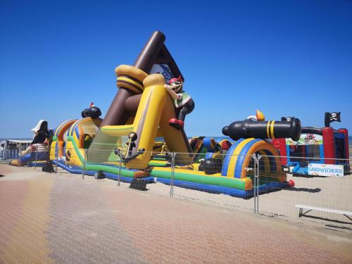 un parc aquatique avec un grand toboggan gonflable dans l'établissement #Kalithéa# Les vacances à la mer, à Bray-Dunes