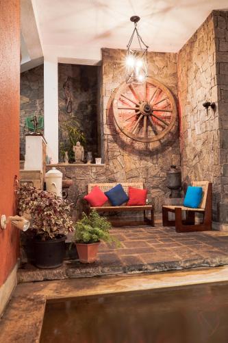 a room with benches and a wall with a wheel at Gruhaya Boutique Villa in Kandy