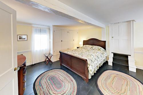 1 dormitorio con 1 cama y 2 alfombras en Nickels-Sortwell House, en Wiscasset