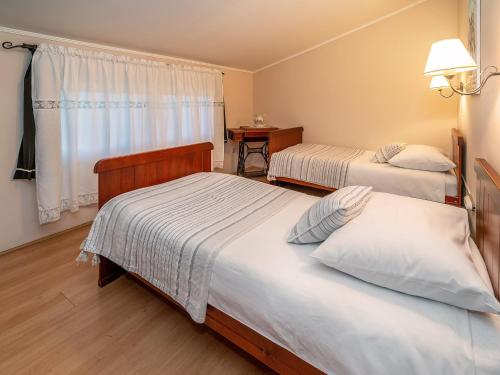 um quarto de hotel com duas camas e uma janela em Apartments Villa Roza em Dražice