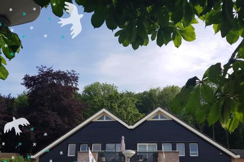 a house with two white birds flying over it at Vakantiewoning Osebos in Gulpen