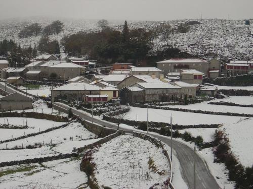 małe miasteczko pokryte śniegiem z drogą w obiekcie Casa de Campo Monte Abades w mieście Terras de Bouro