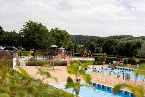 a large swimming pool with people in a playground at Vakantiewoning Osebos in Gulpen