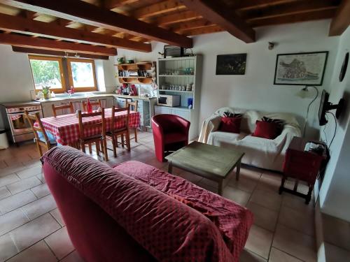 a living room with a red couch and a kitchen at THE BARN, MAISON, PISCINE PRIVATIVE, CALME, WIFI in Carayac