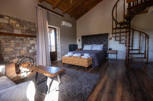 a bedroom with a bed and a staircase in a room at Mylaon Boutique Hotel & Spa in Vitina