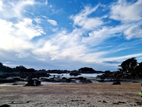 a person standing on a beach near a river at Hotel De L'Europe in Perros-Guirec