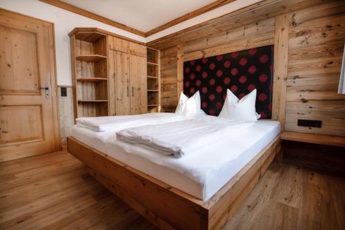 ケーニヒスライテンにあるAppartement Hofmannの木製の壁のベッドルーム1室(大型ベッド1台付)