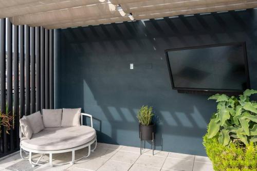a chair and a tv on a blue wall at BO-BOU Suite in Los Angeles