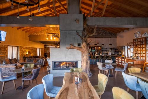 a restaurant with a fireplace and tables and chairs at Mylaon Boutique Hotel & Spa in Vitina