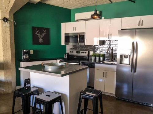 a kitchen with white cabinets and a green wall at BO-BOU Suite in Los Angeles