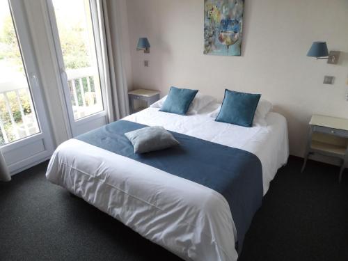 a hotel room with two beds with blue pillows at Hôtel des Vignes - Juliénas in Juliénas