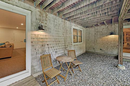 two chairs and a table in a room with a brick wall at Knickerbocker Lake Retreat in Boothbay