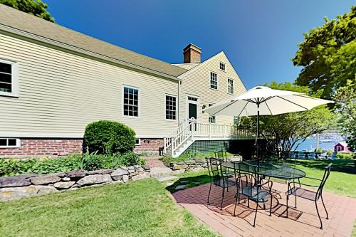 una mesa con sombrilla frente a una casa en Boothbay Lookout, en Boothbay Harbor