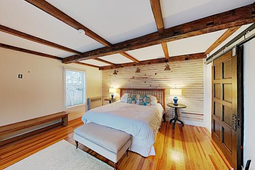 a bedroom with a bed and a wooden wall at Stars and Stripes Forever in Southwest Harbor