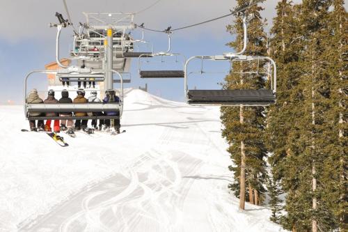 un groupe de personnes sur une remontée mécanique dans la neige dans l'établissement Hop Inn At Antlers Gulch, à Keystone