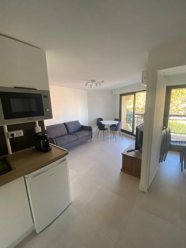 une cuisine et un salon avec un canapé et une table dans l'établissement Frejus Plage Acapulco, à Fréjus