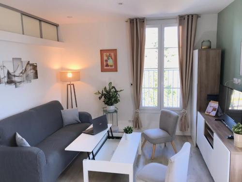 ein Wohnzimmer mit einem Sofa und einem Tisch in der Unterkunft La Villa Soregia in Lattes