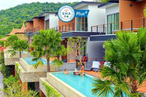 a hotel with a swimming pool in front of a building at Le Resort and Villas in Rawai Beach