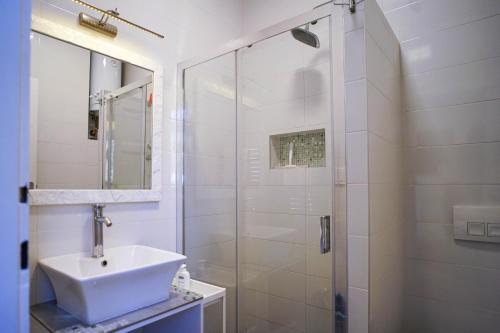 a white bathroom with a sink and a shower at Apartment Park in Belgrade