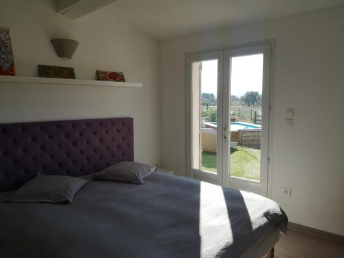 Un dormitorio con una cama y una ventana grande. en maison Moliere, en Aix-en-Provence