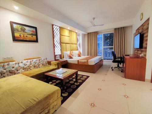 a hotel room with a bed and a couch at The Angel Hotel & Suites near Medanta in Gurgaon