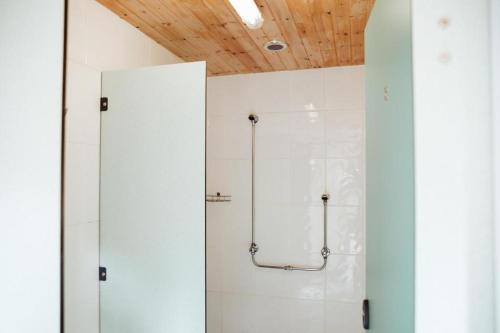 a shower stall in a bathroom with white walls at Willow Valley Glamping in Bude