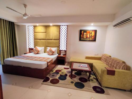 a bedroom with a bed and a couch at The Angel Hotel & Suites near Medanta in Gurgaon