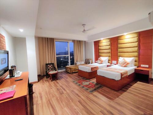 a hotel room with two beds and a flat screen tv at The Angel Hotel & Suites near Medanta in Gurgaon