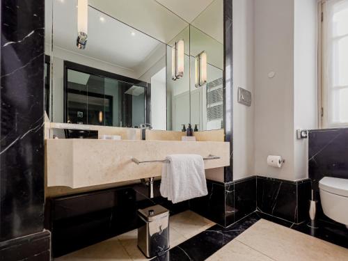 a bathroom with a large mirror and a sink at Grand Hotel San Gemini I UNA Esperienze in San Gemini