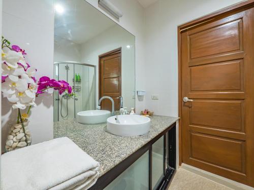 een badkamer met 2 wastafels en een glazen deur bij Condo AVANTA Unit А405 in Ban Tai
