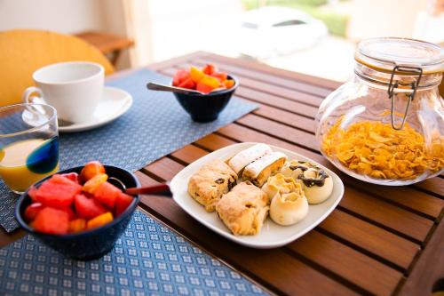 a table with a plate of food and a bowl of fruit at S'Arena Lughente Deluxe Apartment in Alghero