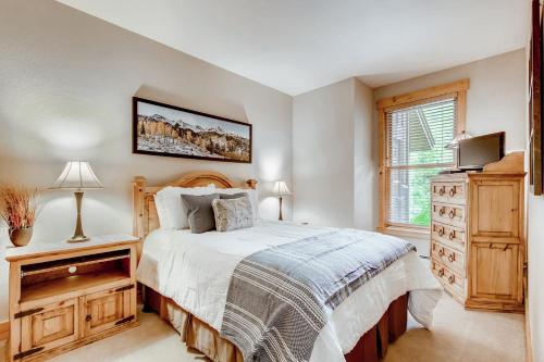 a bedroom with a bed and a dresser and a window at Trappers Crossing Condo Unit 8769 in Keystone