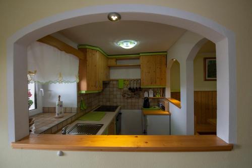 a kitchen with an archway in the middle of it at Apartma Vidmar Otlica in Ajdovščina