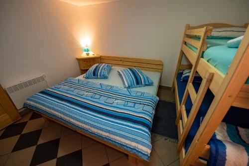 a bedroom with two bunk beds and a checkerboard floor at Apartma Vidmar Otlica in Ajdovščina