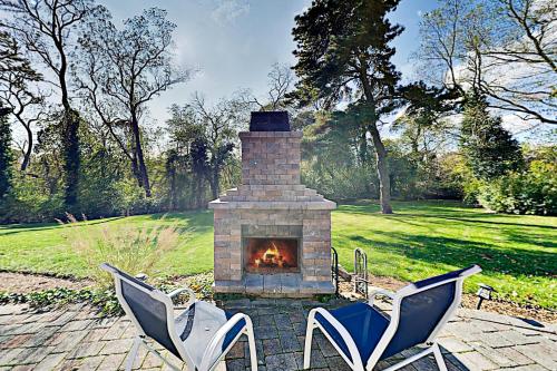 two chairs and a brick fireplace in a yard at Pleasant Bay Retreat in Orleans