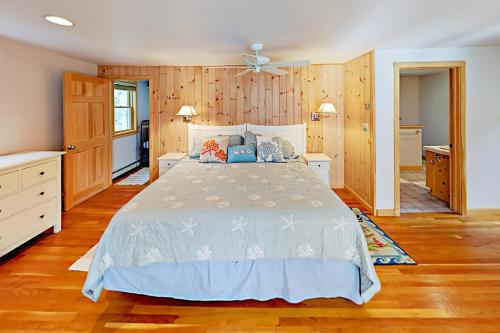 1 dormitorio con 1 cama y suelo de madera en Sea Pine Palace en Wellfleet