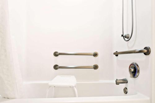 a bathroom with a toilet and towel bars at Microtel Inn & Suites by Wyndham Albuquerque West in Albuquerque