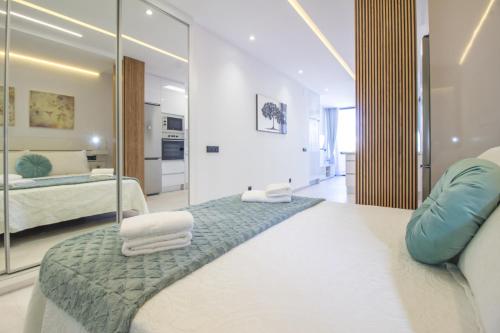 ein Schlafzimmer mit einem Spiegel und einem Bett mit Handtüchern in der Unterkunft Mainstream home with balcony By CanariasGetaway in Guanarteme