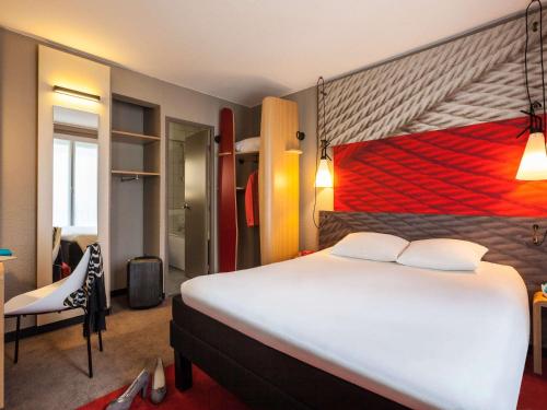 Pokój hotelowy z dużym łóżkiem i krzesłem w obiekcie ibis Paris Gare De L'Est TGV w Paryżu
