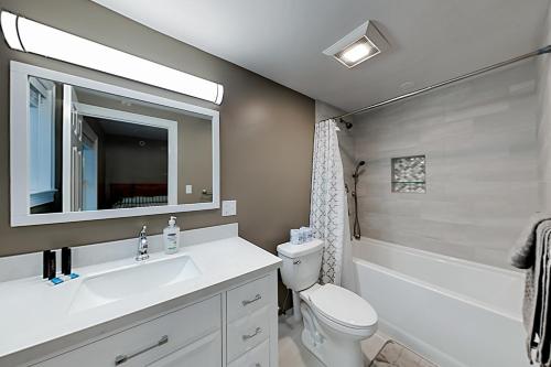 a bathroom with a sink and a toilet and a mirror at Summer Ocean Escapes in Dennis Port