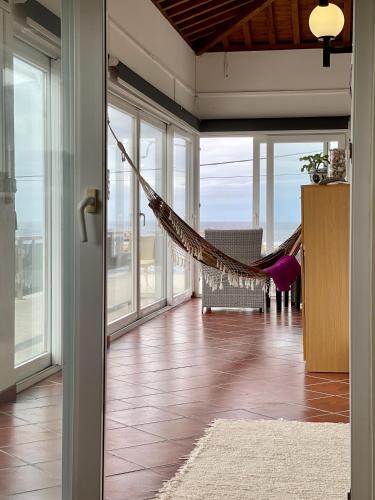 a room with a hammock in a room with windows at Carpe Diem Azores in Mosteiros