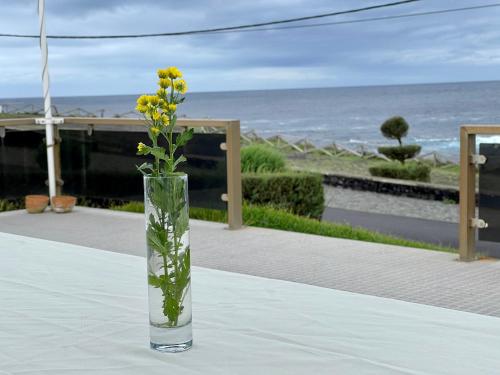 a vase with a yellow flower in it on a table at Carpe Diem Azores in Mosteiros