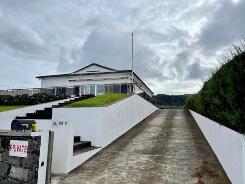 a white house with stairs leading up to it at Carpe Diem Azores in Mosteiros
