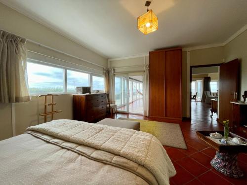 a bedroom with a large bed and a large window at Carpe Diem Azores in Mosteiros