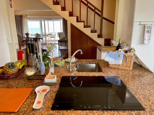 a kitchen counter with a sink and a staircase at Carpe Diem Azores in Mosteiros