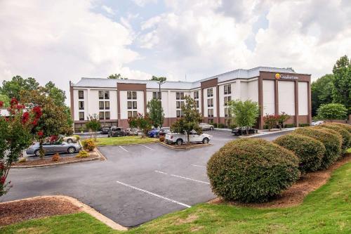 a large building with cars parked in a parking lot at Comfort Inn Greenville - Haywood Mall in Greenville