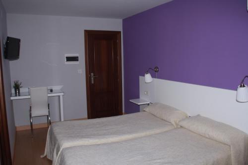 a bedroom with a bed and a purple wall at Verona in Granada