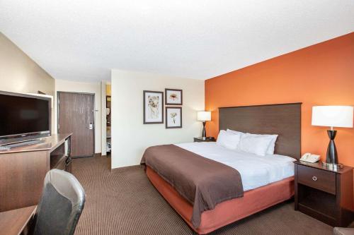 A bed or beds in a room at AmericInn by Wyndham Ottumwa